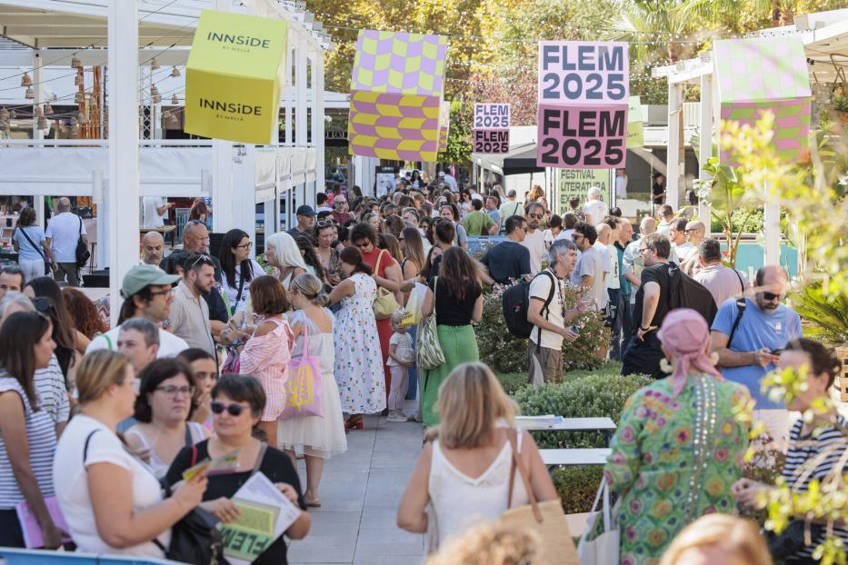 Menschenmenge auf einem literarischen Festival mit FLEM-2025-Bannern im Freien.