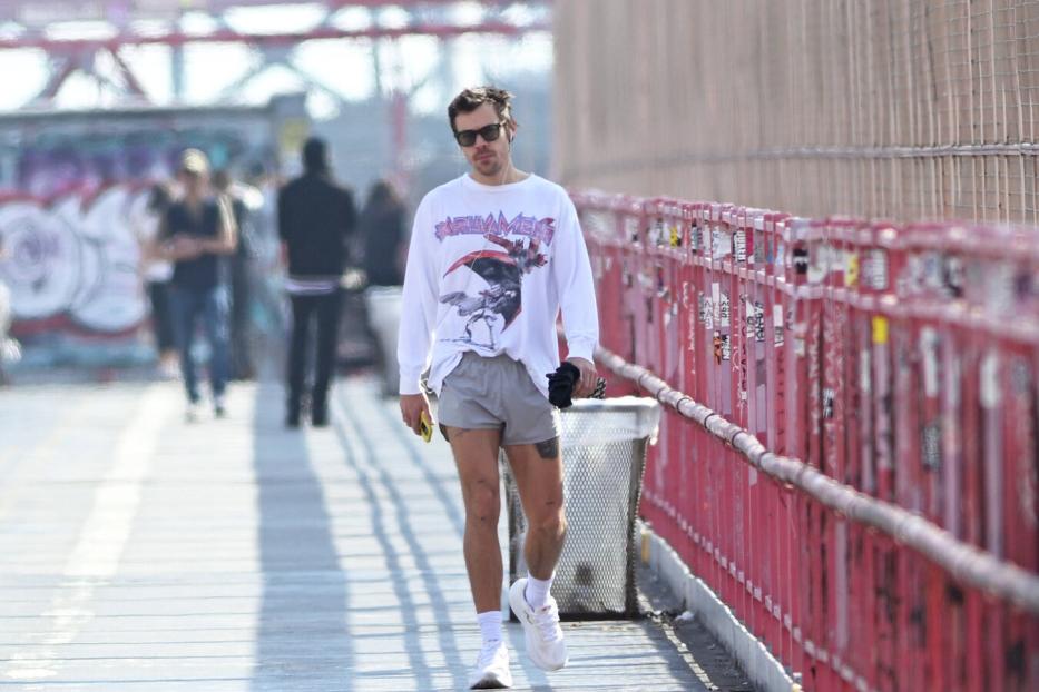 Harry Styles in weißen Langarmshirt, grauen, sehr kurzen Shorts und Sonnenbrille in New York beim Joggen.