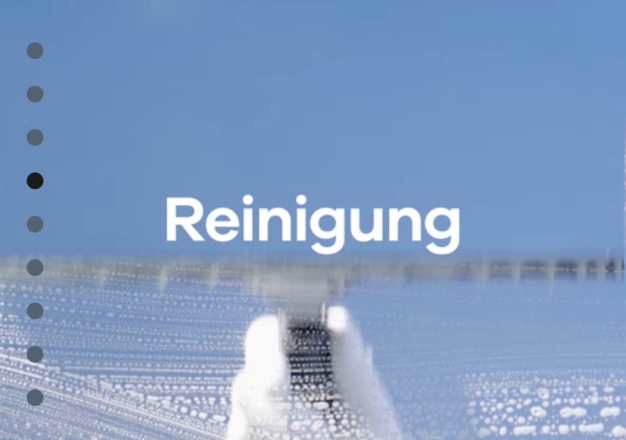 Hand wischt mit weißem Tuch über eine Glasfläche mit Wasserperlen, blauer Himmel im Hintergrund.