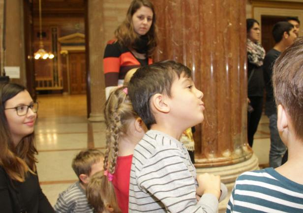 Eine Gruppe von Kindern steht in einem Gebäude mit Säulen.