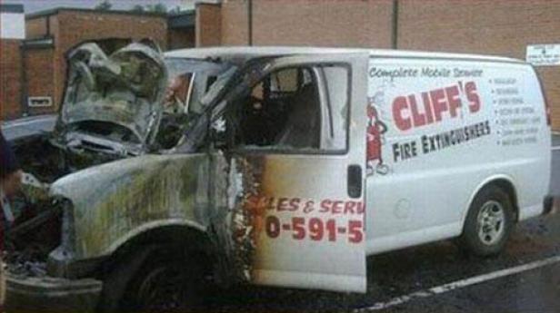 Ein ausgebrannter Lieferwagen von „Cliff's Fire Extinguishers“ mit geöffneter Tür.