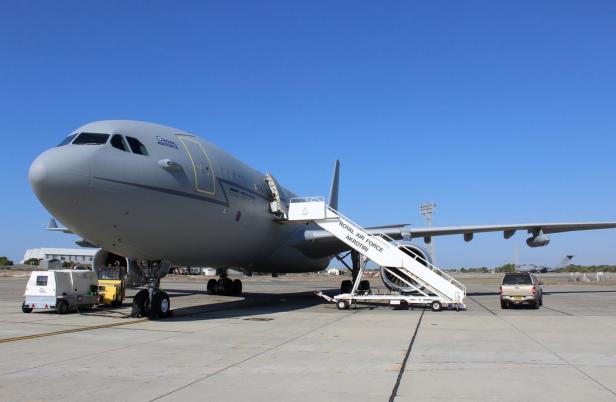 Ein graues Flugzeug der Royal Air Force steht auf einem Flugfeld mit einer Treppe.