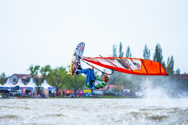 Ein Windsurfer macht einen Sprung über das Wasser.