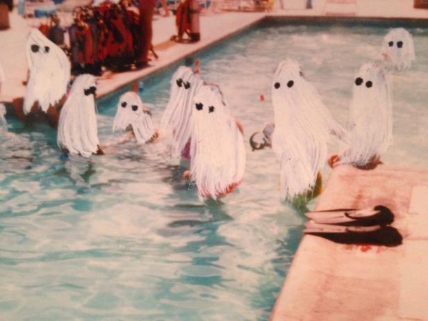 Mehrere als Geister verkleidete Personen stehen in einem Schwimmbad.
