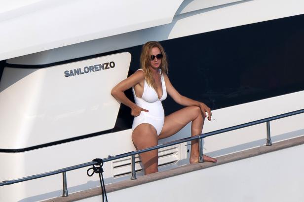 Uma Thurman in einem weißen Badeanzug auf einer San Lorenzo Yacht mit einer Zigarette.