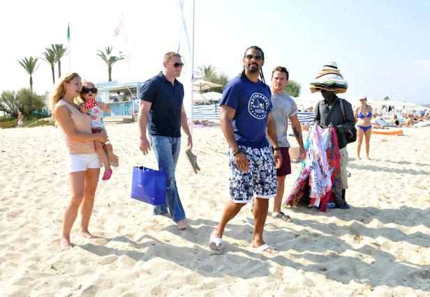 Eine Gruppe von Menschen geht am Strand entlang.