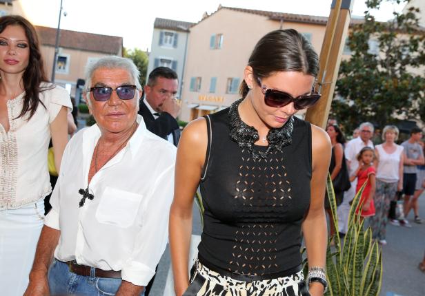 Zwei Frauen und ein Mann posieren vor einem Gebäude in Saint-Tropez.