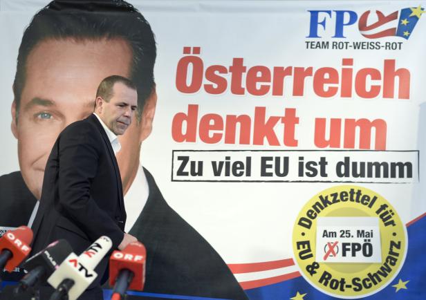 Ein Mann geht an einem Wahlplakat der FPÖ vorbei.