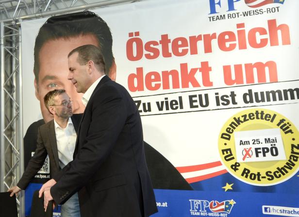 Zwei Männer stehen vor einem Wahlplakat der FPÖ mit der Aufschrift „Österreich denkt um“.