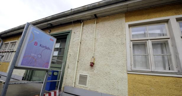 Ein Schild mit der Aufschrift „Karlich, Gäste“ steht vor einem gelben Gebäude.