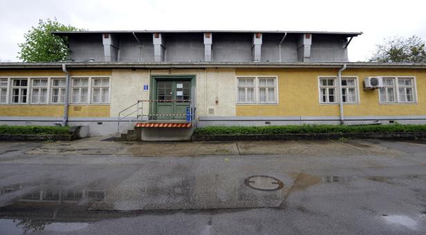 Ein gelbes Gebäude mit der Nummer 5 über dem Eingangsbereich.