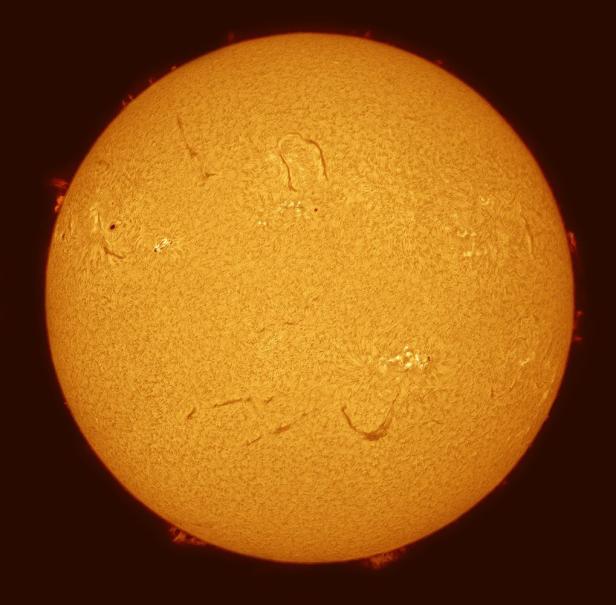 Die Sonne mit Sonnenflecken und Protuberanzen, aufgenommen durch ein Teleskop.