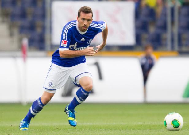 Ein Fußballspieler von Schalke 04 rennt auf dem Spielfeld einem Ball hinterher.