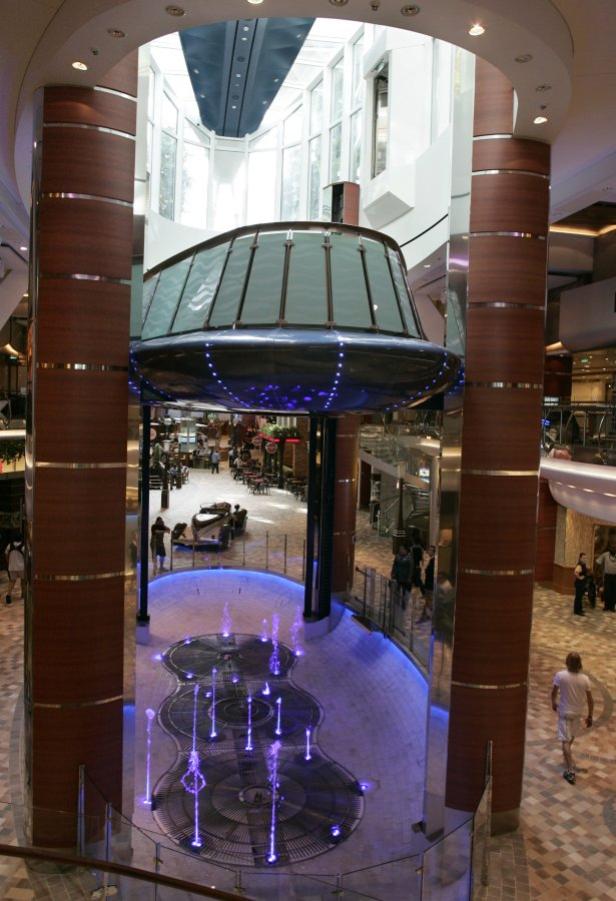 Blick auf einen Innenbereich mit Springbrunnen und einem schwebenden, verglasten Aussichtspunkt.