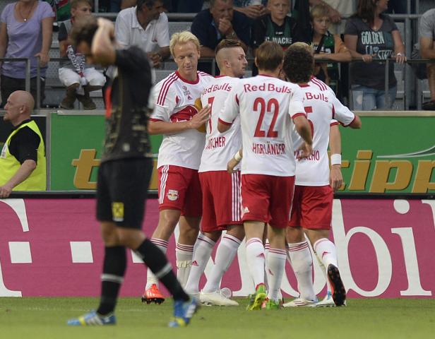Fußballspieler von Red Bull Salzburg feiern auf dem Spielfeld.