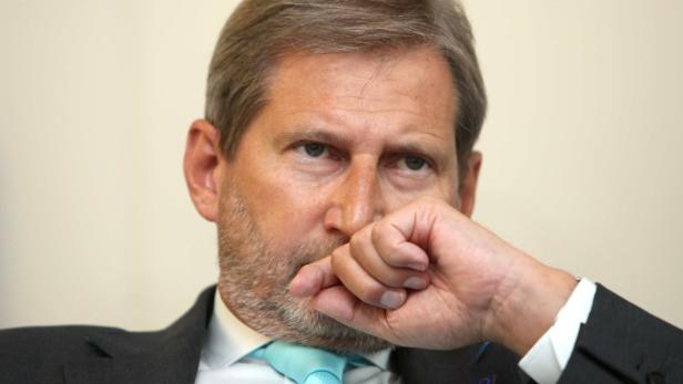 EU-Kommissar, Johannes Hahn, ÖVP Ein Mann im Anzug mit hellblauer Krawatte bedeckt seinen Mund mit der Hand.