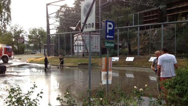 Feuerwehrleute pumpen Wasser von einer überfluteten Straße in der Nähe von Schildern in Waiphoffen ab.