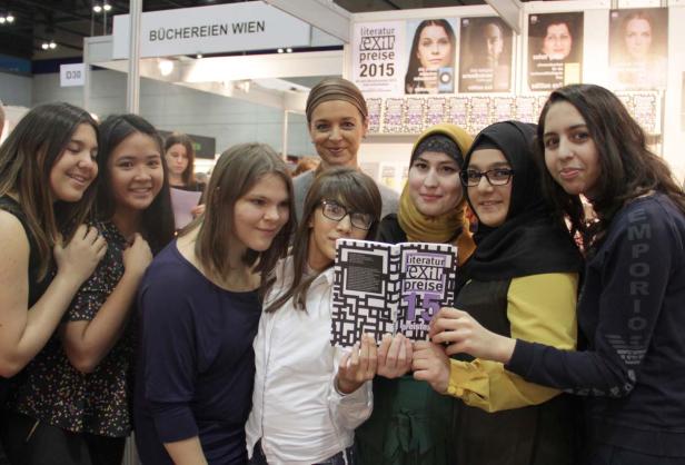 Eine Gruppe junger Frauen posiert mit einem Buch der „Literatur Exit Preise 2015“.