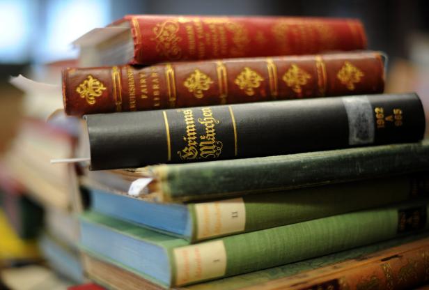 Ein Stapel alter Bücher, darunter eine Ausgabe von „Grimms Märchen“.