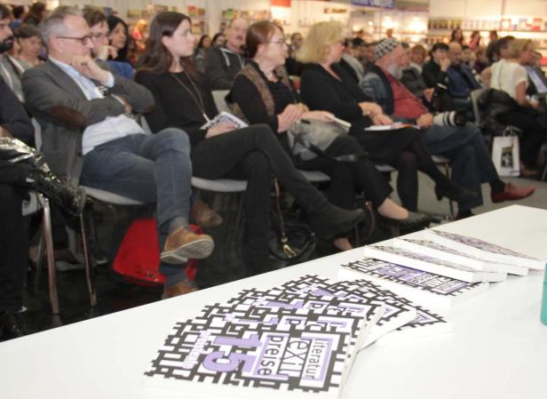 Zuschauer sitzen bei einer Buchvorstellung im Publikum.