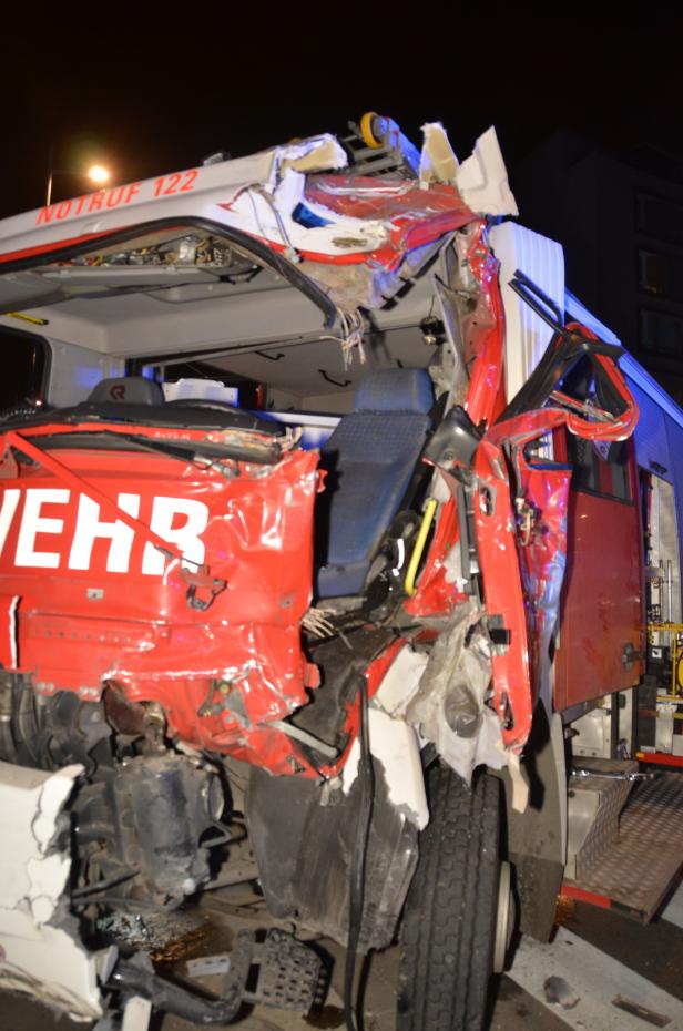 Ein stark beschädigtes Feuerwehrfahrzeug nach einem Unfall bei Nacht.