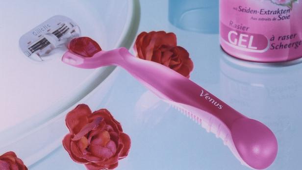 Ein Venus-Rasierer liegt neben roten Rosen und einer Dose Rasiergel.