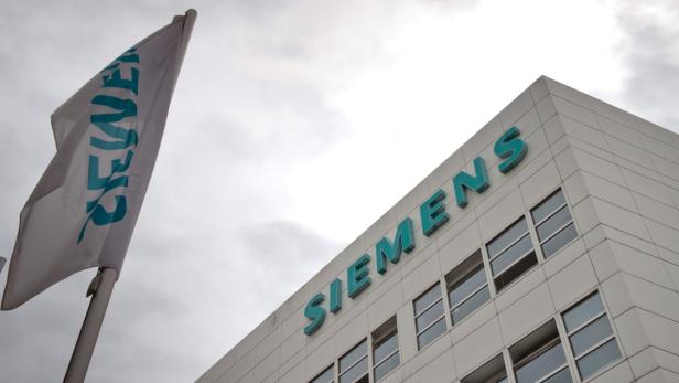 Ein Siemens-Gebäude mit einer wehenden Siemens-Flagge davor.