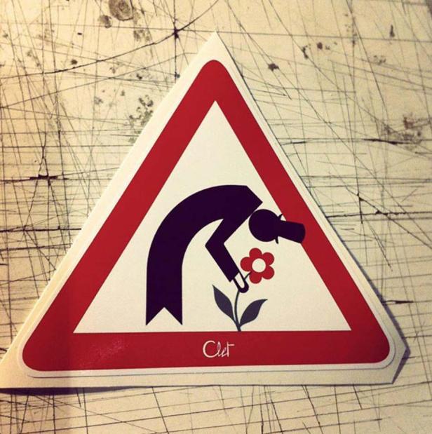 Ein Verkehrsschild zeigt eine stilisierte Person, die sich nach einer Blume bückt.