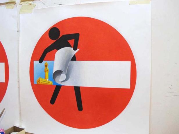 Eine Person entfernt das Verbotsschild und gibt den Blick auf Florenz frei.