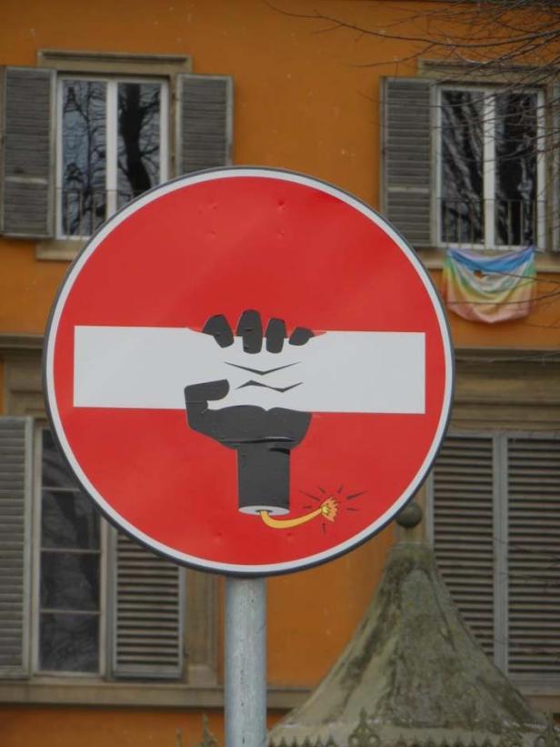 Ein Stoppschild wurde mit einer Faust und einer Bombe übermalt.