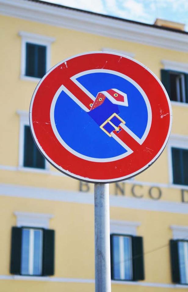 Ein Verkehrsschild mit einem durchgestrichenen Gürtel vor einem gelben Gebäude.