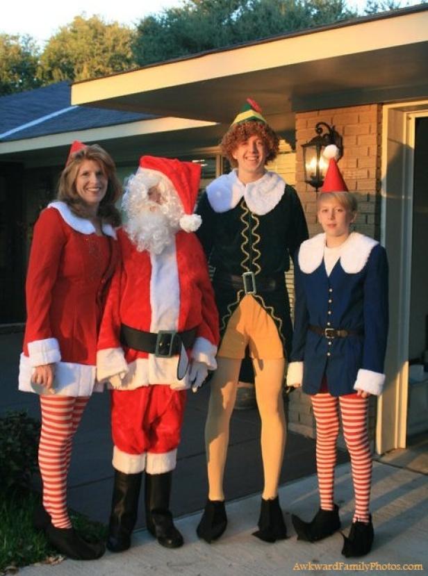 Eine Familie posiert in Weihnachtskostümen vor einem Haus.