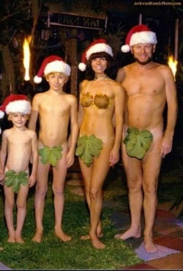 Eine Familie mit Weihnachtsmützen, spärlich mit Blättern bekleidet, posiert für ein Foto.