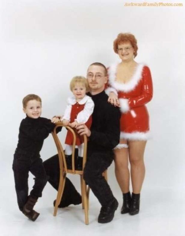 Eine Familie posiert für ein Weihnachtsfoto, die Mutter trägt ein rotes Weihnachtsfrauenkostüm.