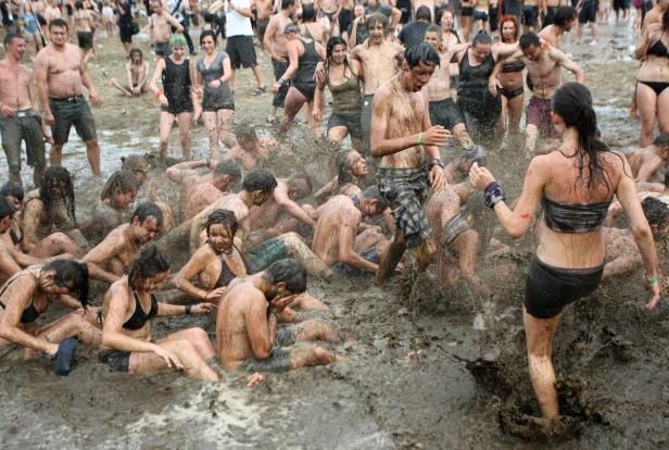 Eine Gruppe von Menschen vergnügt sich in einem Schlammbad.