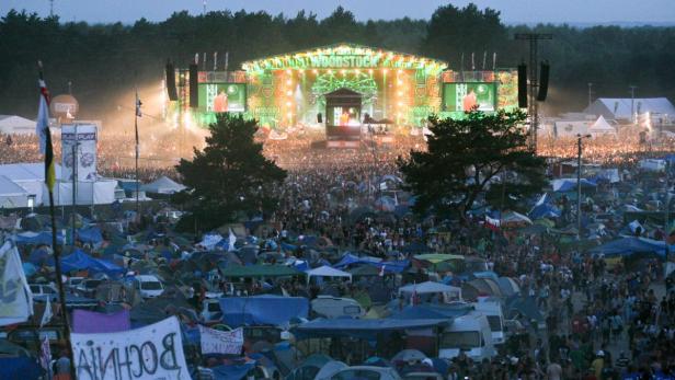 Blick über ein Festivalgelände mit Bühne und vielen Menschen und Zelten.