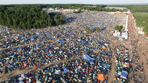 Luftaufnahme eines großen Campingplatzes mit vielen Zelten und Menschen.