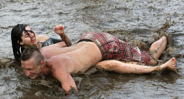 Ein Mann und eine Frau haben eine Schlammschlacht und lachen.