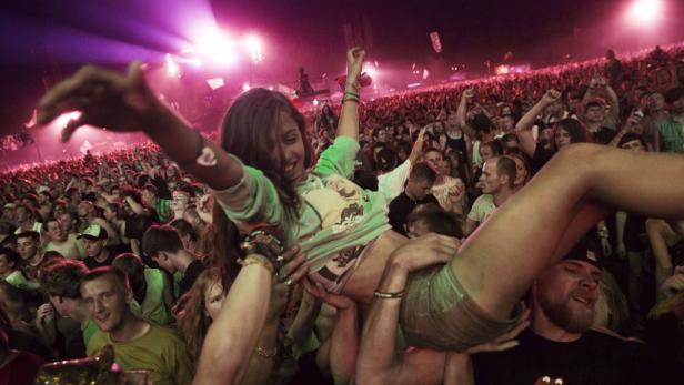 Eine junge Frau wird auf den Schultern durch eine feiernde Menschenmenge getragen.