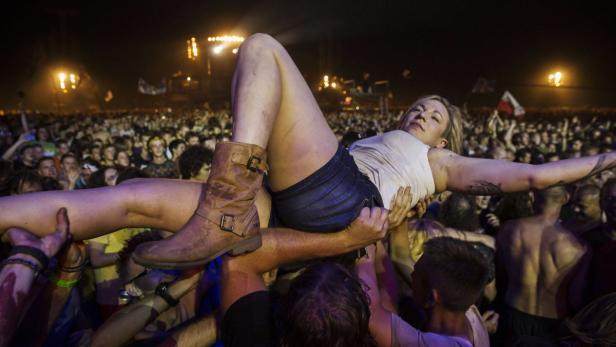 Eine Frau wird während eines Konzerts von der Menge getragen.