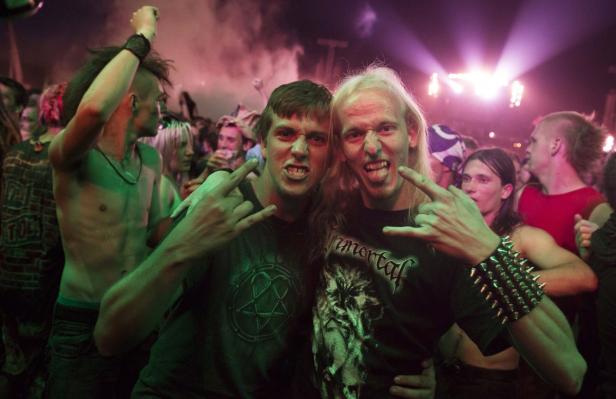 Zwei Männer posieren auf einem Heavy-Metal-Konzert mit der Pommesgabel.