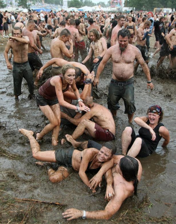 Menschen wälzen sich während eines Musikfestivals im Schlamm.