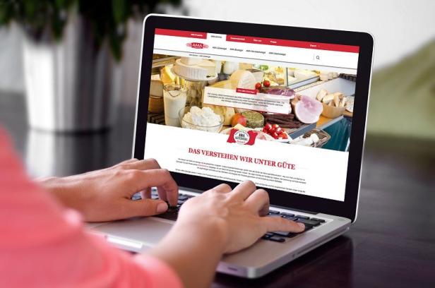 Eine Person tippt auf einem Laptop, der die Website der AMA-Marketing GmbH anzeigt.