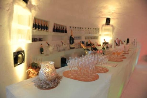 Eine Bar mit Champagnerflaschen und Gläsern in einer eisigen Umgebung.