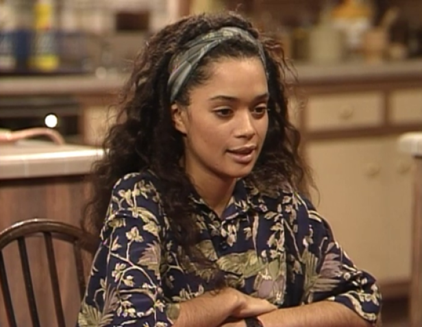 Lisa Bonet sitzt in einem floralen Hemd in einer Küche.
