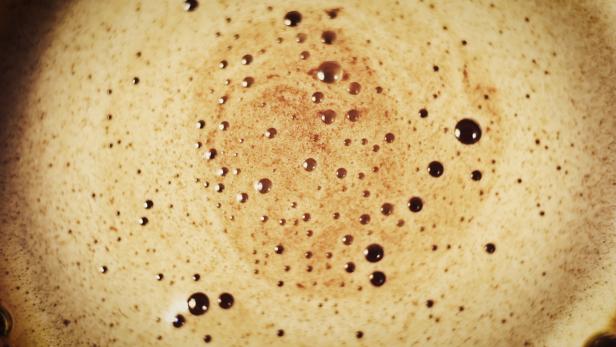 Nahaufnahme von Kaffeemilchschaum mit kleinen Bläschen.
