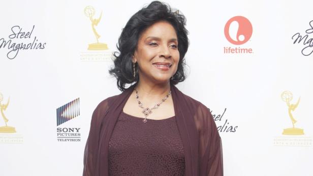 Phylicia Rashad lächelt auf einer Veranstaltung vor Logos wie Sony Pictures und Lifetime.