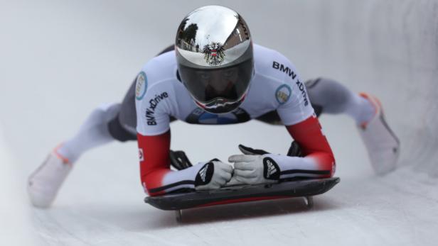Ein Skeleton-Athlet liegt auf seinem Schlitten und rast die Eisbahn hinunter.