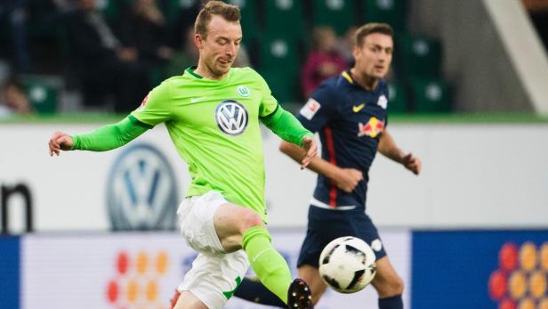 Ein Fußballspieler in Grün schießt den Ball.