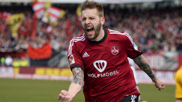 Ein jubelnder Fußballspieler des 1. FC Nürnberg auf dem Spielfeld.
